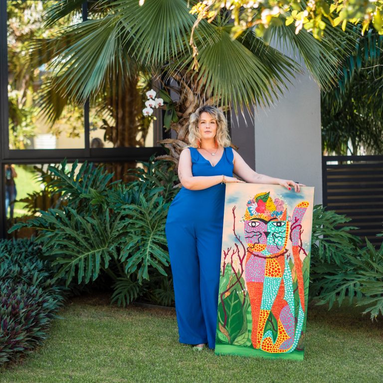 Michelle Diehl pintando uma obra inspirada em gatos, simbolizando sua superação e resiliência.