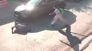Idosa sendo resgatada de um bueiro aberto por testemunhas em Cuiabá.